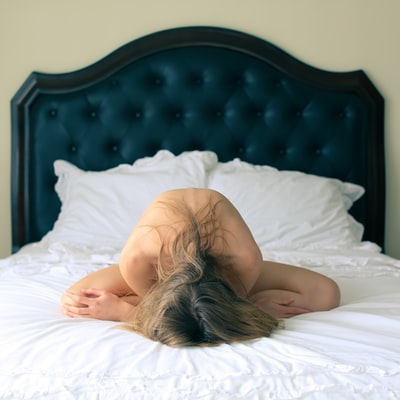 躺在床上用白毯子盖住身体的女人